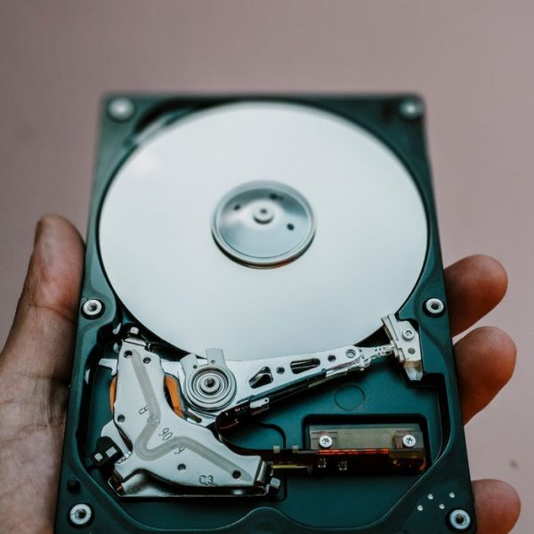 Close-up view of an open hard drive held in a hand, illustrating data storage technology.
